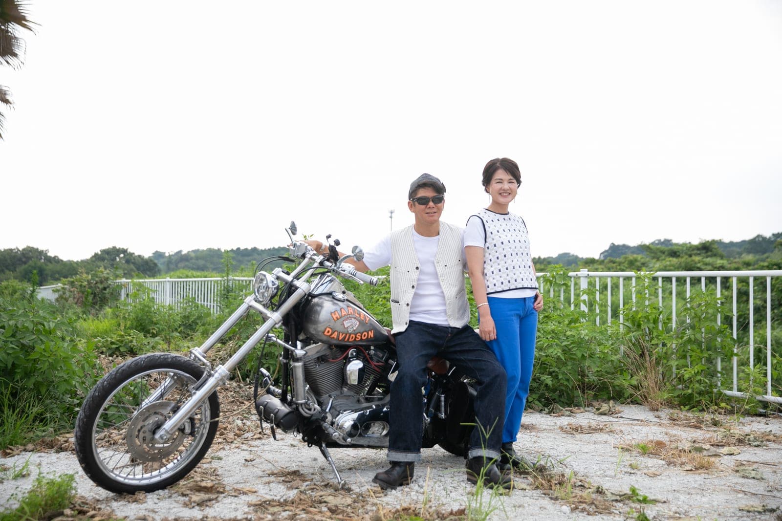 草原でハーレーダビッドソンと並ぶふたり