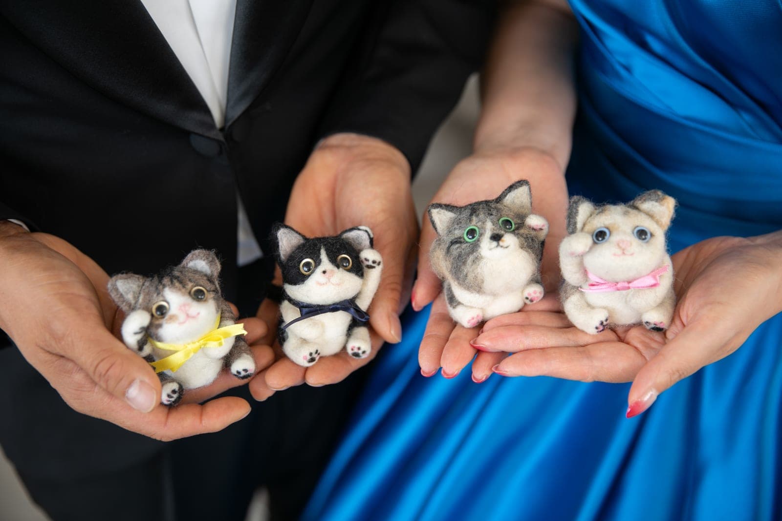 ふたりの手のひらに乗せた 3 匹の猫のぬいぐるみ